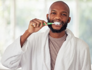  jovem escovando os dentes em casa